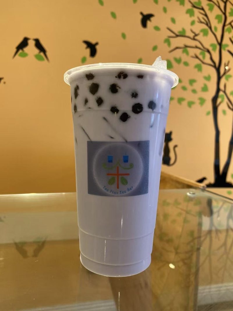Taro milk tea with boba in front of the shop’s tree wall